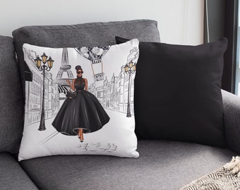 May include: White throw pillow with a black and white illustration of a woman in a black dress walking down a street in Paris. The Eiffel Tower is in the background. The pillow has a black and white border.