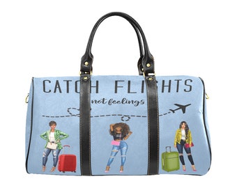 May include: A light blue travel bag with black leather handles and trim. The bag features the text "CATCH FLIGHTS not feelings" and illustrations of three women with luggage. A dotted line and airplane graphic are also present.
