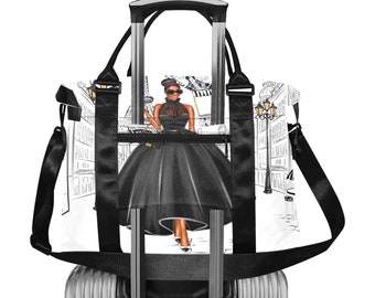 May include: A black and white travel bag featuring a fashion illustration of a woman in a black dress, sunglasses, and a purse. The background depicts a Parisian street scene with the Eiffel Tower. The bag has black straps and a silver handle.