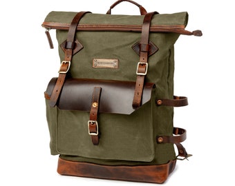 May include: A green canvas backpack with brown leather accents and straps. The backpack has a roll-top closure and a metal buckle. The brand name "GRAYZANDER" is printed on a metal tag.