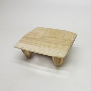 May include: A small, light wood table with a rectangular top and four legs. The table is made of natural wood and has a rustic, handmade look.
