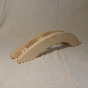 May include: A wooden bridge toy for children, made of natural light wood. The bridge is shaped like an arch and has a smooth surface.