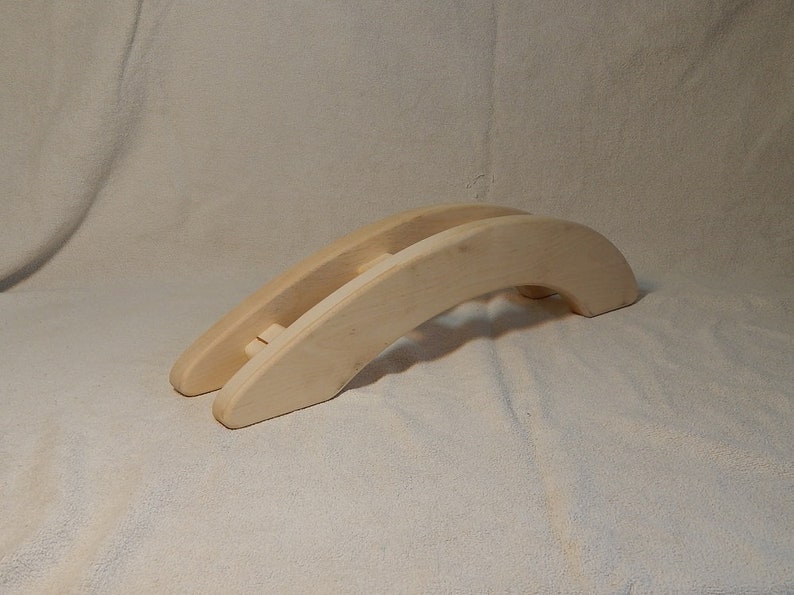 Puede incluir: Un juguete de puente de madera para ni&ntilde;os, hecho de madera natural clara. El puente tiene forma de arco y tiene una superficie lisa.