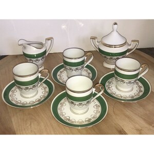 Puede incluir: Un juego de seis tazas de t&eacute; y platillos de porcelana blanca con ribetes verdes y dorados. El juego incluye una jarra de crema y un azucarero.