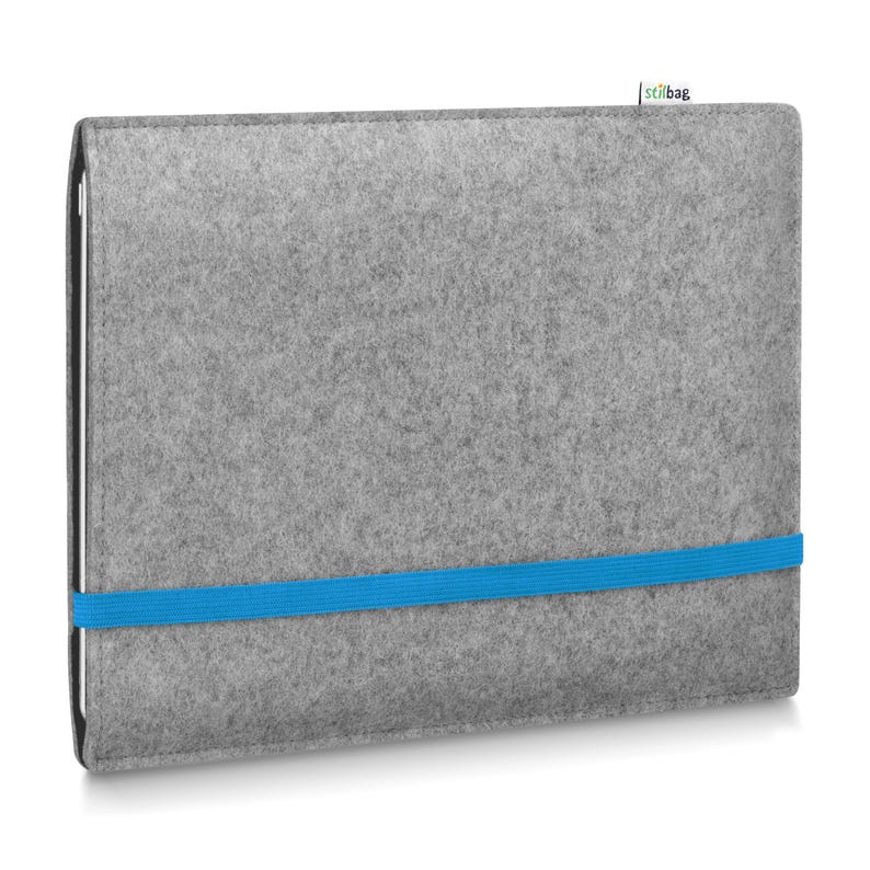 May include: A rectangular light gray felt sleeve for a tablet or laptop, featuring a bright blue elastic band wrapped horizontally around the center to secure it. A small white fabric tag with the green and black text stilbag is attached.