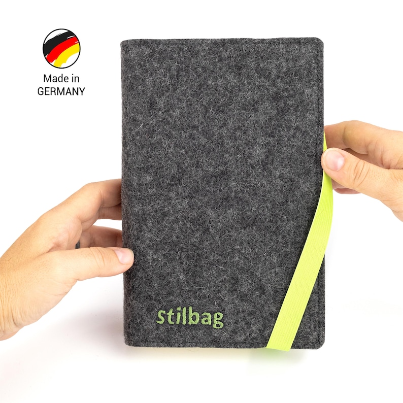 May include: A gray felt case with a lime green zipper pull. The case has the text "stillbag" embroidered on the front. Made in Germany.