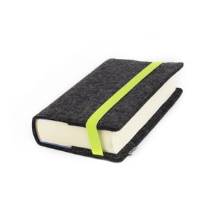 May include: A gray felt book cover with a bright green elastic closure. The cover is designed to protect a book.