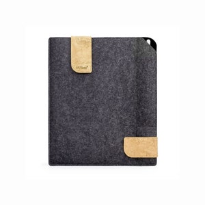 Puede incluir: Una funda para tablet de fieltro gris con detalles de corcho. La funda tiene una solapa con la palabra "stilbag" impresa.
