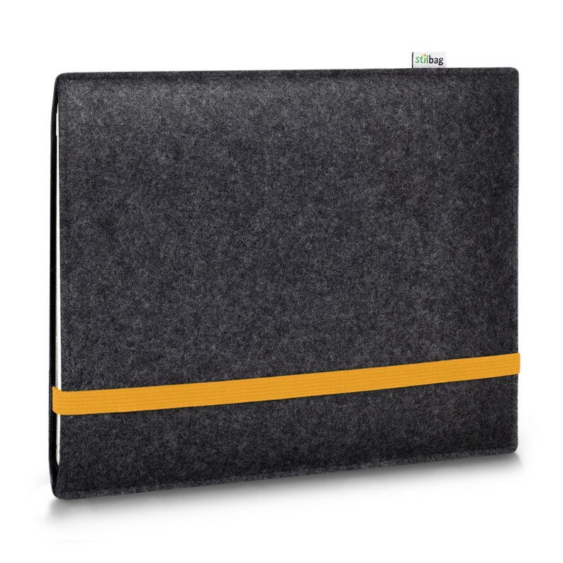 May include: A dark charcoal gray felt laptop sleeve with a rectangular shape and a textured surface. A bright yellow elastic band wraps horizontally around the center to secure the case. A small white fabric tag with the text stilbag is attached.