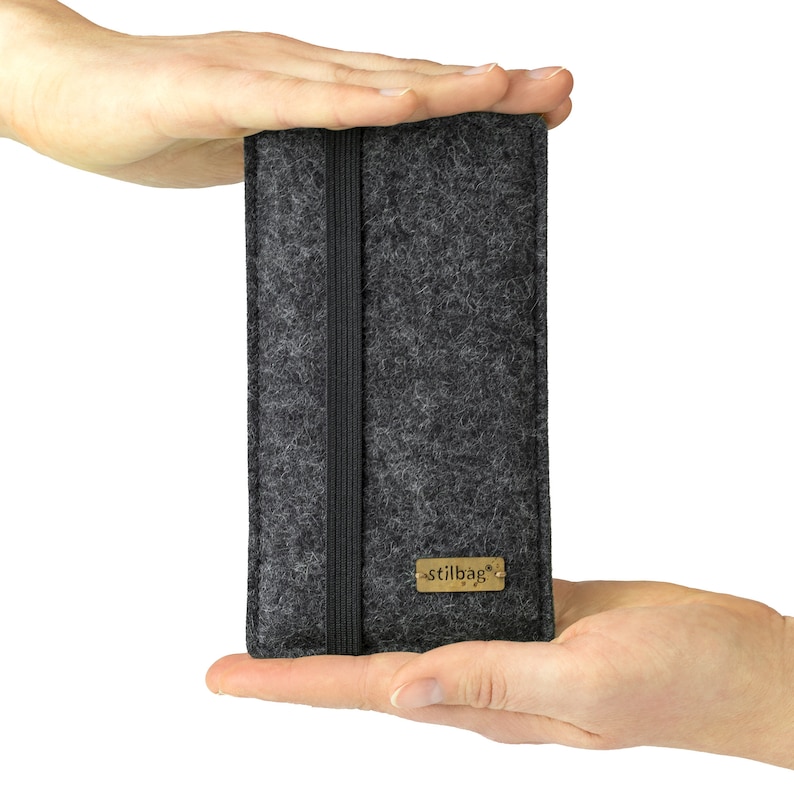 May include: A gray felt phone case with a black elastic band and a gold label that says "stilbag".