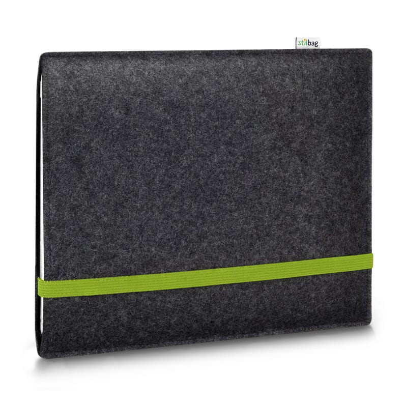 May include: A dark charcoal gray felt laptop sleeve featuring a vibrant lime green elastic band wrapped horizontally around the center to secure the closure. A small white fabric tag with the text stilbag is attached to the top edge.
