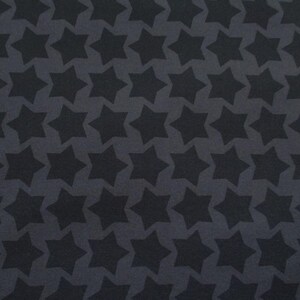 Könnte beinhalten: Dunkelgrauer Stoff mit einem sich wiederholenden Muster aus schwarzen sechsspitzigen Sternen. Die Sterne sind gleichmäßig verteilt und erzeugen ein symmetrisches Design. Der Stoff hat eine matte Oberfläche.