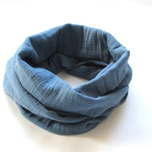 Könnte beinhalten: Ein blauer Rundschal aus weichem, strukturiertem Stoff. Der kreisförmige Schal ist einfarbig und scheint aus einem leichten Material zu bestehen. Der Schal ist ein vielseitiges Accessoire.