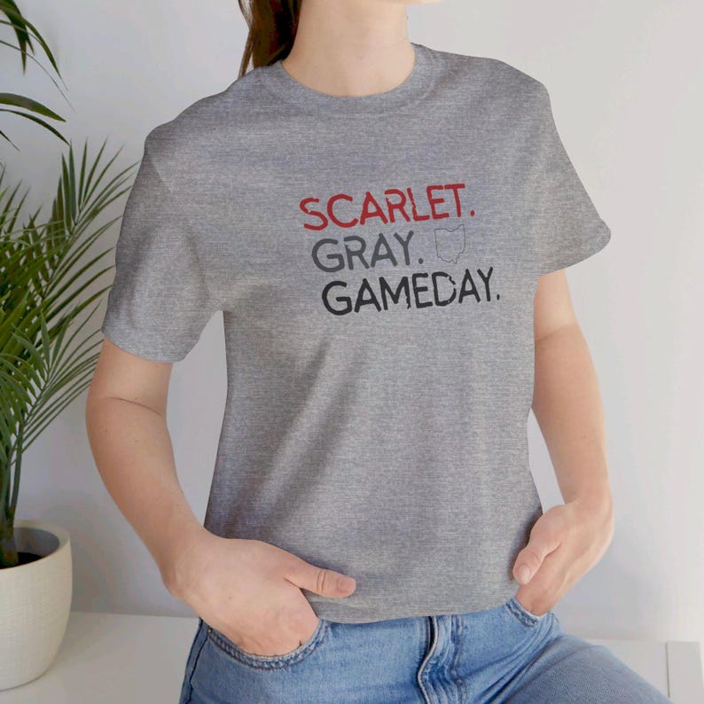 K&ouml;nnte beinhalten: Graues T-Shirt mit dem Text "SCARLET. GRAY. GAMEDAY." in schwarzer Schrift und einem roten Umriss des Bundesstaates Ohio.