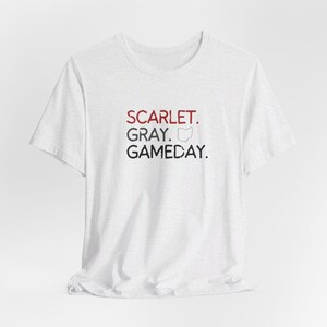 K&ouml;nnte beinhalten: Wei&szlig;es T-Shirt mit dem Text "SCARLET. GRAY. GAMEDAY." in schwarzer und roter Schrift. Ein kleiner Umriss des Bundesstaates Ohio ist im Text enthalten.