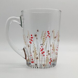 May include: A clear glass mug with a hand-painted design of red berries and brown stems on a white background.