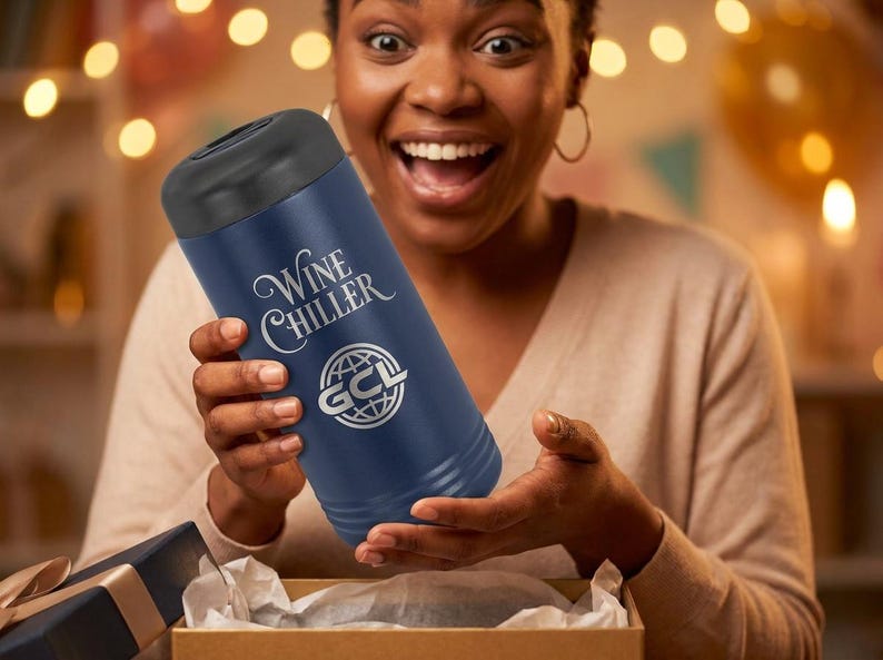 May include: A navy blue wine chiller with a black top is held by a person. The text "Wine Chiller" and a logo are printed on the side. The person is opening a gift box.