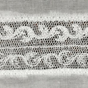 May include: White lace trim with a delicate floral pattern. The lace is woven in a mesh pattern with small holes throughout.