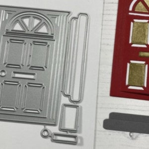 May include: A silver metal die-cut of a door with a window above it. The die-cut is for crafting and scrapbooking.