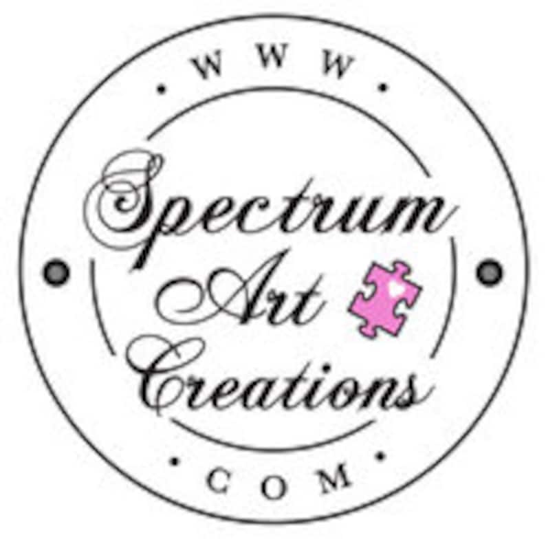May include: Circular logo for Spectrum Art Creations, featuring elegant script text and a puzzle piece icon. The logo is primarily black and white, with a pink heart in the puzzle piece. The website address www.SpectrumArtCreations.com is also included.