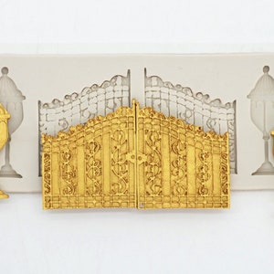 May include: A silicone mold for baking cake decorations. The mold features a decorative gate with ornate details and two matching lamp posts.