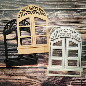 Puede incluir: Tres troqueles de ventana de metal, uno en negro, uno en marrón y uno en plata. Los troqueles tienen la forma de una ventana con un arco decorativo y un diseño de paneles.