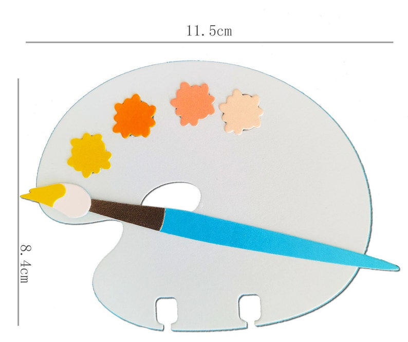 May include: A white artist's palette with a blue handle brush and colorful paint splotches. The palette measures 11.5 cm wide and 8.4 cm high. The brush has a brown handle and a yellow and white brush head. The paint splotches are yellow, orange, and peach.