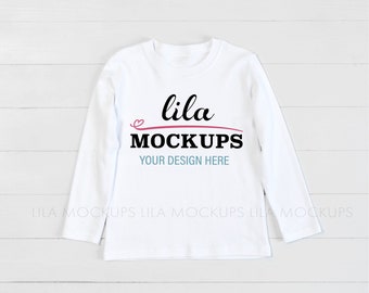Puede incluir: Maqueta de camisa blanca de manga larga con el texto "lila MOCKUPS YOUR DESIGN HERE" sobre un fondo de madera blanca.