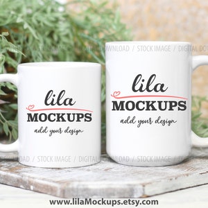 May include: Two white ceramic mugs with black text that reads "lila MOCKUPS add your design". The mugs are on a wooden surface with green plants in the background.