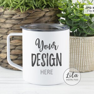 May include: White stainless steel travel mug with a black lid and handle. The mug has the text "Your Design Here" printed on the front in black.