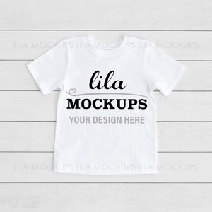 May include: White t-shirt mockup with the text "lila MOCKUPS YOUR DESIGN HERE" on a white wood background.