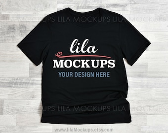 Puede incluir: Maqueta de camiseta negra con el texto "lila MOCKUPS" y "YOUR DESIGN HERE" en blanco. El texto "lila" está en rosa con un símbolo de corazón.