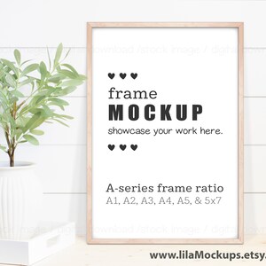 May include: A light wood frame mockup with a white background. The frame is on a white wood background. The text "frame MOCKUP" is in black text. The text "showcase your work here." is in black text. The text "A-series frame ratio A1, A2, A3, A4, A5, & 5x7" is in black text. There is a small potted plant to the left of the frame.