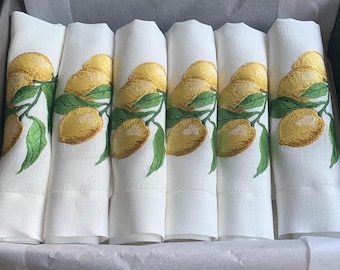 May include: Set of six white linen napkins with embroidered lemon designs. The lemons are yellow with green leaves.