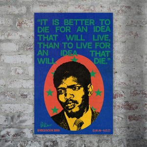 May include: A rectangular poster with a blue background featuring a portrait of Steve Biko in yellow and black. The text reads: IT IS BETTER TO DIE FOR AN IDEA THAT WILL LIVE, THAN TO LIVE FOR AN IDEA THAT WILL DIE. BANTU STEVE BIKO 12.18.46-9.12.77.