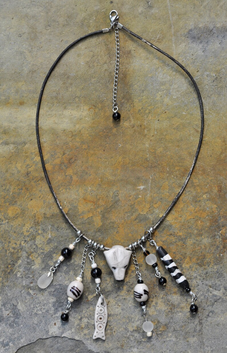 Ketting met ijsbeer hoofd tribal vis zwart-witte kralen en zeeglas hanger