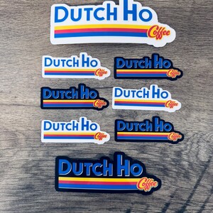 May include: A collection of stickers with the text "DUTCH HO Coffee" in a blue, yellow, and red design. The stickers vary in size and background color, with some having a white border and others a black border. The word "Coffee" is in a cursive font.