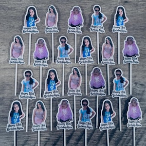 Puede incluir: Una colecci&oacute;n de veinte adornos individuales para cupcakes con fotos de una persona a distintas edades, cada uno unido a un palito blanco. Cada adorno incluye el texto "Happy 18th Birthday Alyssa" impreso en negro en la base.