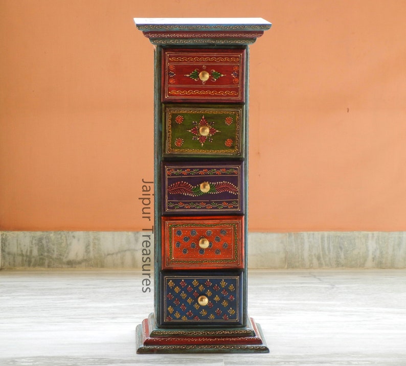 K&ouml;nnte beinhalten: Eine sechsschubladen-Holzkiste mit farbenfrohen handbemalten Designs und goldenen Akzenten. Jede Schublade hat ein anderes Muster und eine andere Farbe, darunter Rot, Gr&uuml;n, Blau und Lila. Die Kiste steht auf einem Holzboden.