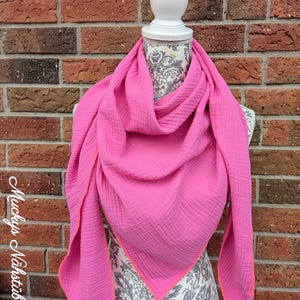 Könnte beinhalten: Ein leuchtend pinker Schal mit neonorangem Rand, drapiert auf einer Büste. Der Schal aus strukturiertem Stoff wird vor einer Backsteinmauer präsentiert. Der Text "Muckys Nähstübchen" ist links zu sehen. Der Schal ist ca. 150 cm lang.