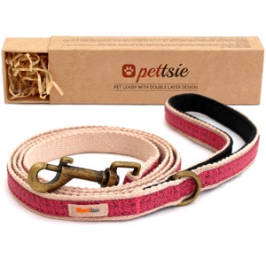 Peut inclure: Une laisse pour chien rose et beige avec un design à double couche. La laisse a un fermoir en métal et une boîte en carton marron avec le texte "pettsie" et "PET LEASH WITH DOUBLE LAYER DESIGN".