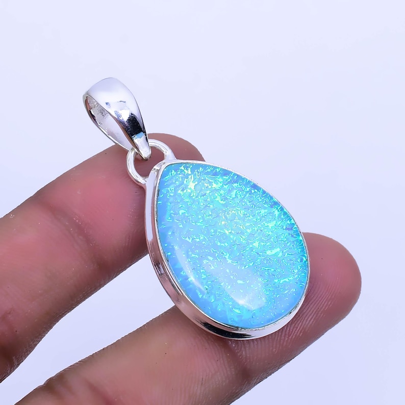 May include: A teardrop-shaped blue opal pendant set in sterling silver. The opal has a shimmering, iridescent finish.