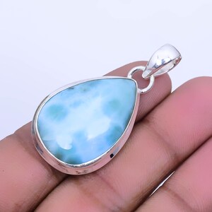 May include: A teardrop-shaped pendant with a light blue and green gemstone set in sterling silver.