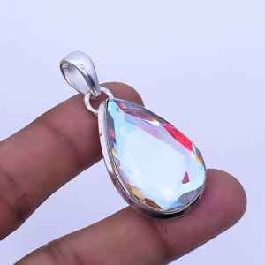 May include: A teardrop-shaped pendant featuring a clear iridescent gemstone set in sterling silver.
