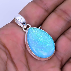 May include: A teardrop-shaped blue opal pendant set in sterling silver. The opal has a sparkly, iridescent finish.