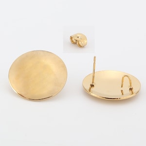 May include: A pair of gold-toned earring blanks with a round, flat surface and a post with a butterfly backing.