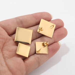 May include: Three gold square-shaped earrings with a post and butterfly backing.