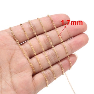 Op de afbeelding: Een fijne goudkleurige ketting met rechthoekige schakels van 1,7 mm breed wordt getoond tegen een lichte huidskleur. De close-up toont de fijne details en de warme tint van het metaal.