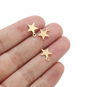 May include: Three gold-colored metal star charms with a loop on the top for attaching to jewelry or other crafts.