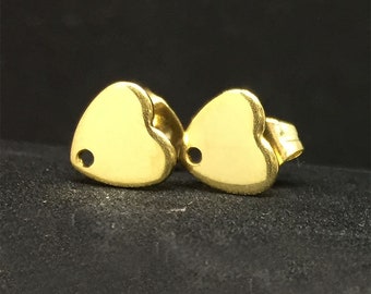 May include: A pair of gold heart-shaped stud earrings. The earrings have a small hole in the center of each heart.